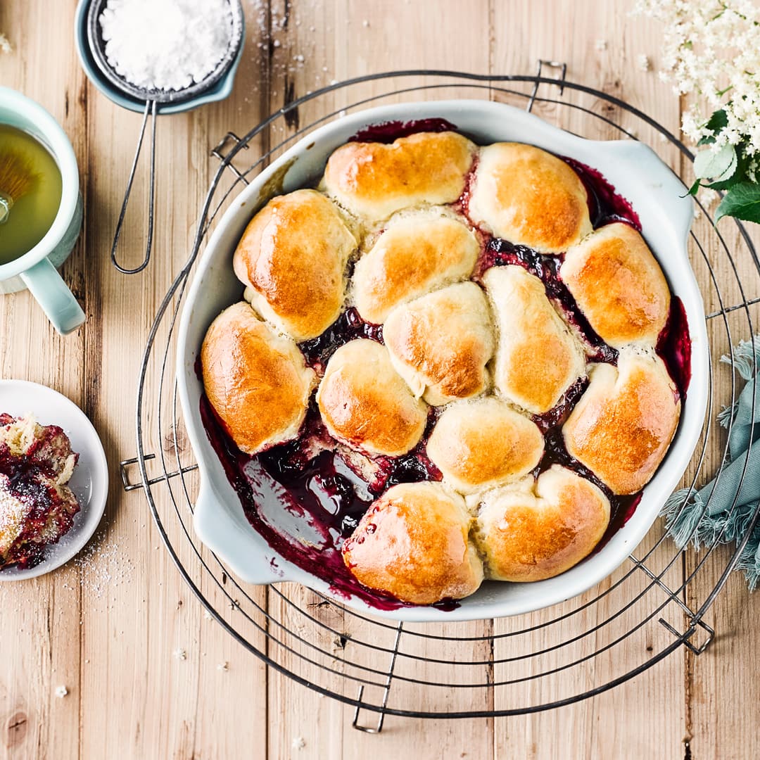 Probieren Sie unsere Variante dieser traditionellen Süßspeise aus Süddeutschland: Buchteln aus Hefe, Weizenmehl und Mandelmilch gefüllt mit Holunderblütengelee – fertig in 90 Minuten!