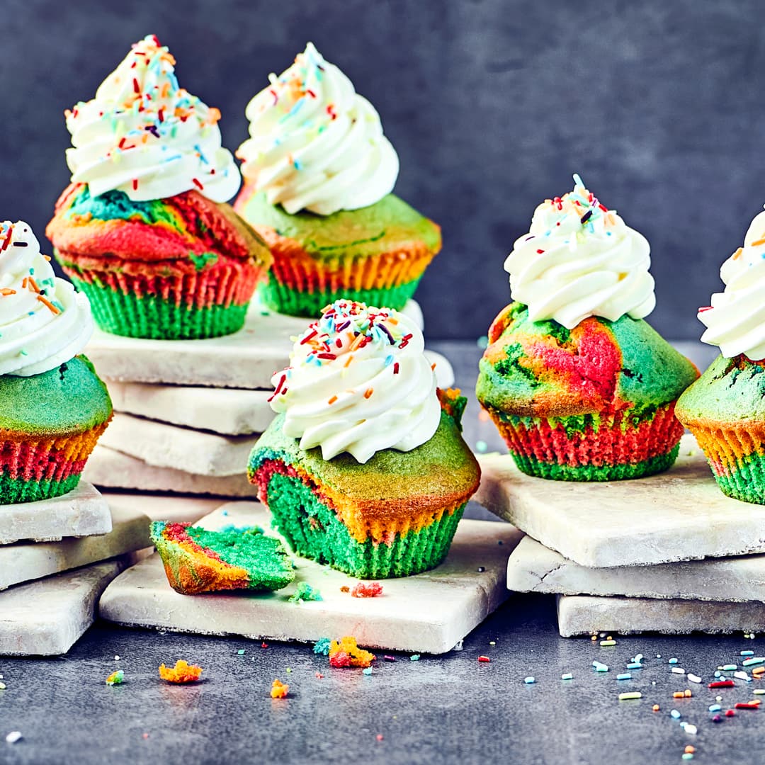 Regenbogen-Muffins mit Sahne und Streusel-Topping