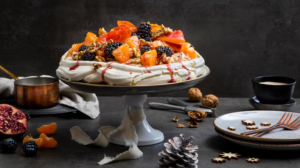 Luftige Baisertorte mit weihnachtlich gewürzter Mascarponecreme und einem fruchtigen Topping aus Grapefruit – probieren Sie unser Weihnachts-Pavlova-Rezept aus!