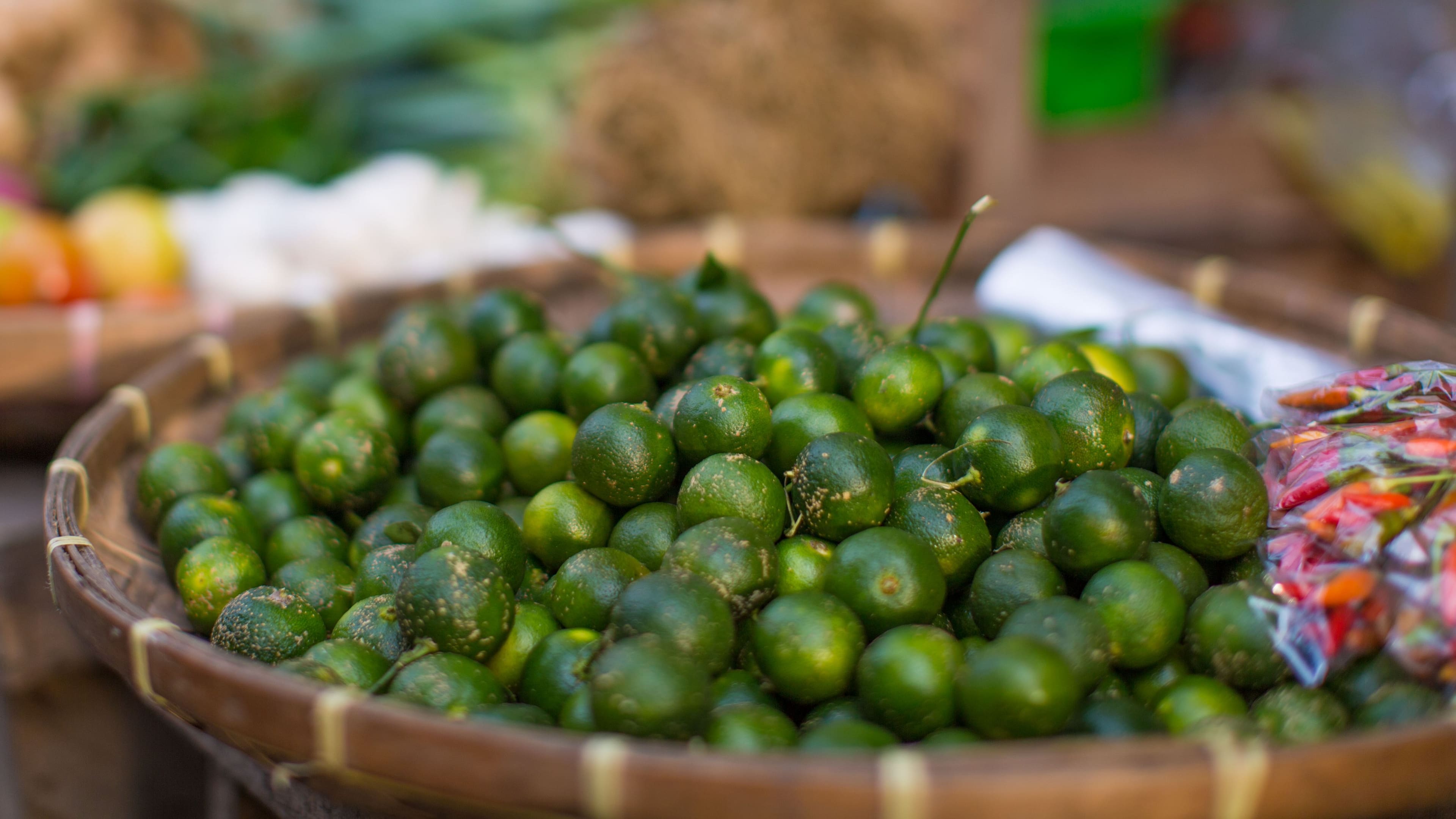 Grüne Kalamansi liegen einladend auf Markt aus.