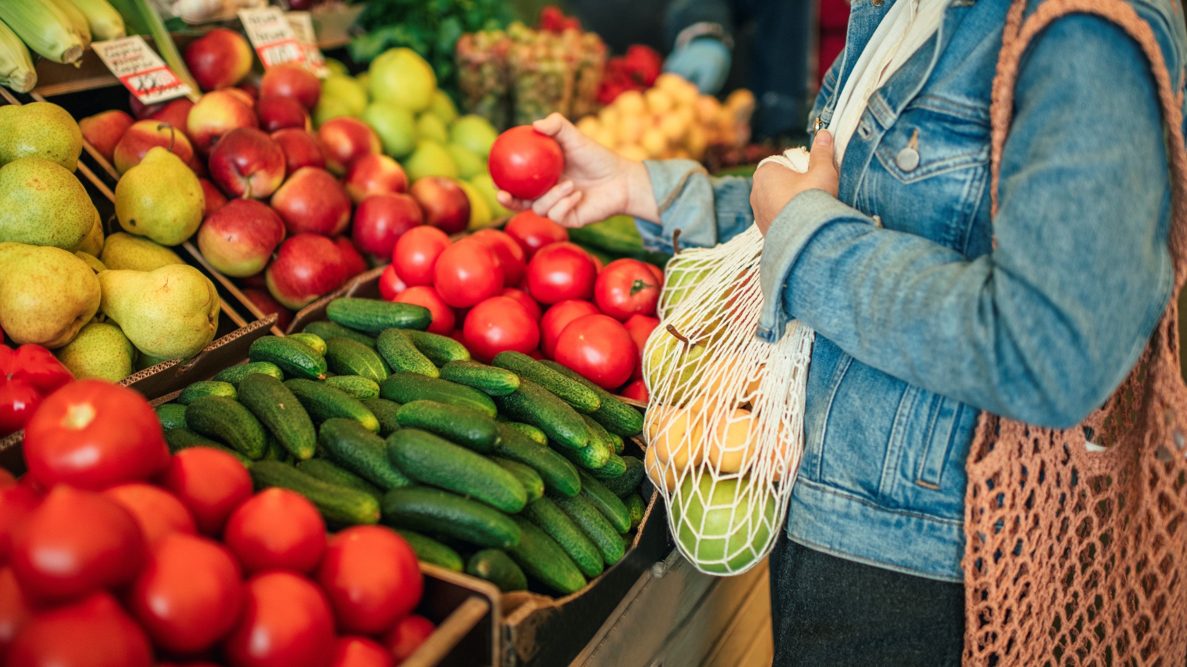 Frau kauft plastikfrei Essen mit einem Gemüsenetz